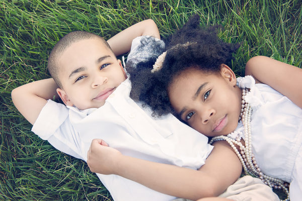 Little siblings lying in the grass